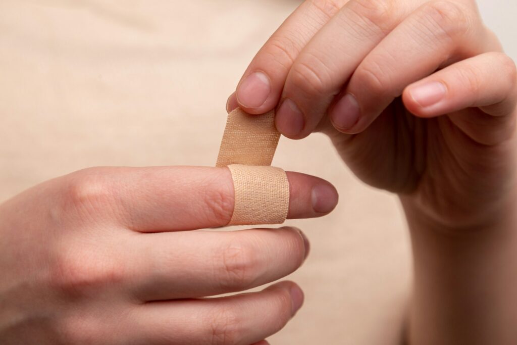 person applying band aid on finger