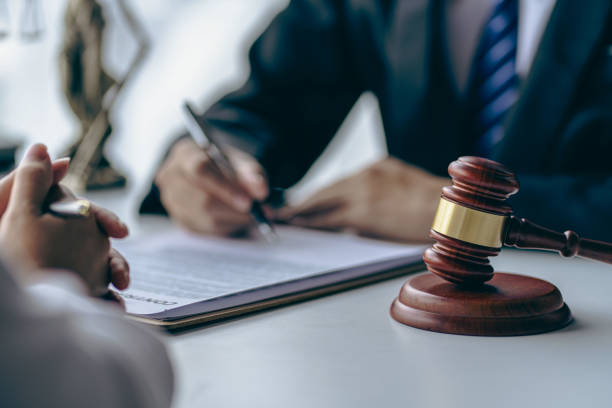 Lawyer and client discussing legal documents with gavel on table, representing criminal defense consultation at Bryan Fagan PLLC.