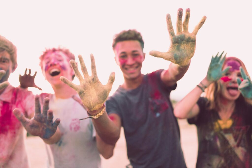 teens with paint on face and hands having fun