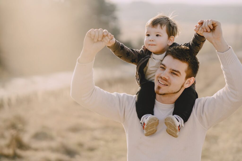 man carrying a toddler on his shoulders