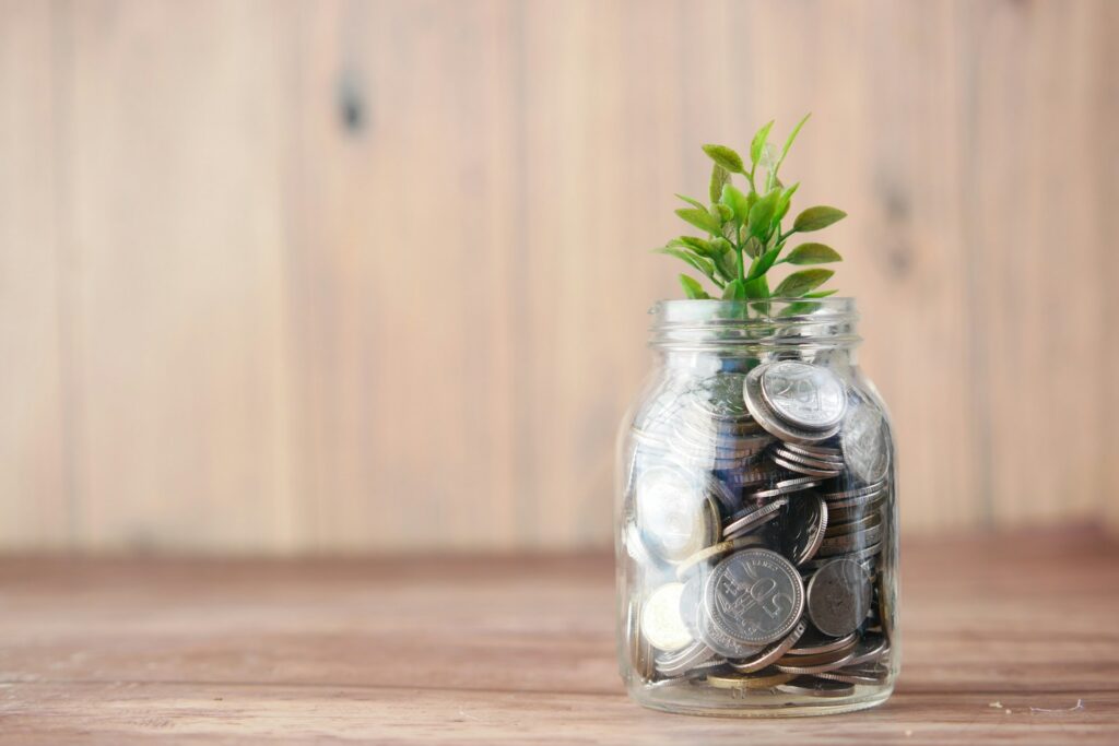a jar filled with coins and a plant
