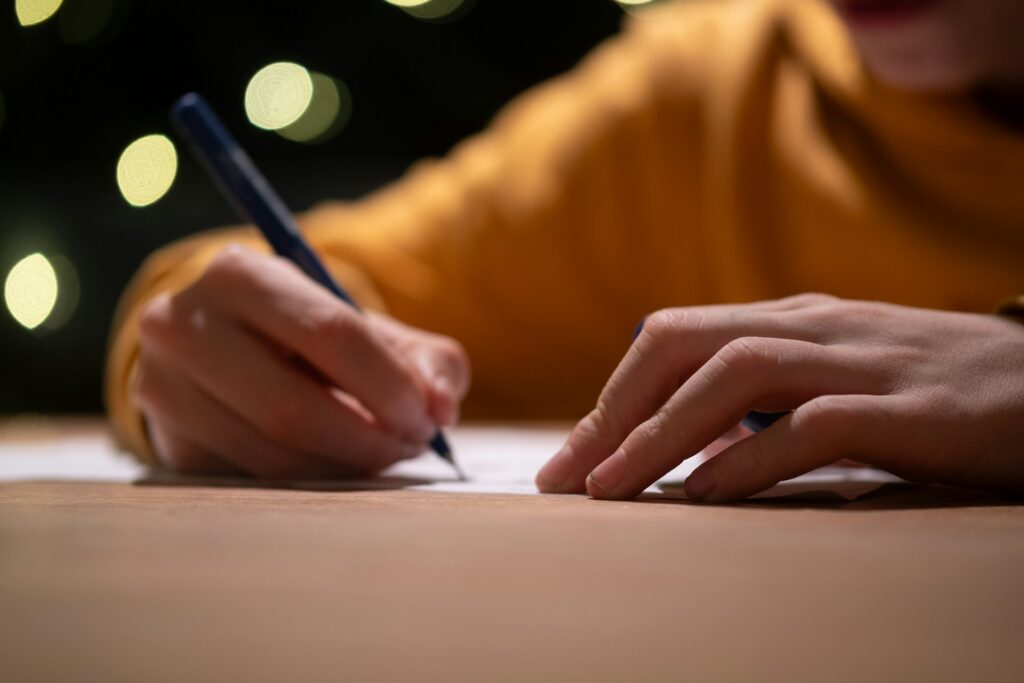 alexander-van-steenberge-gWjJsIGNnbY-unsplash a person writing on a piece of paper