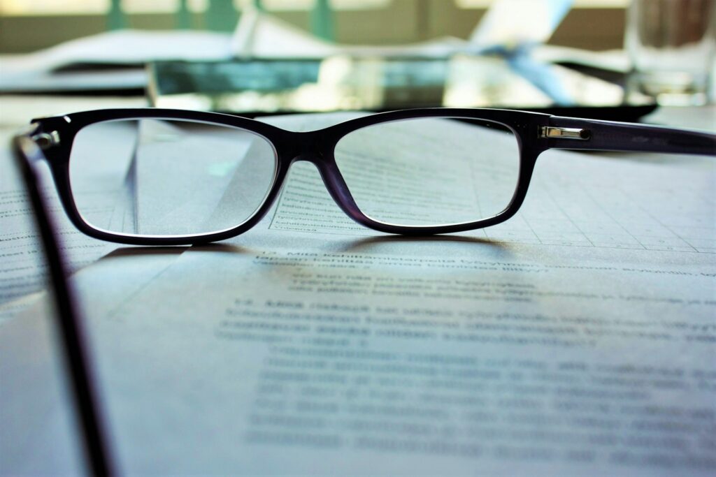 black framed eyeglasses on top of a document