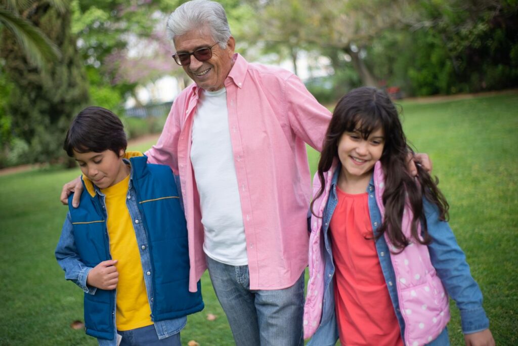 elderly man walking with grandkids