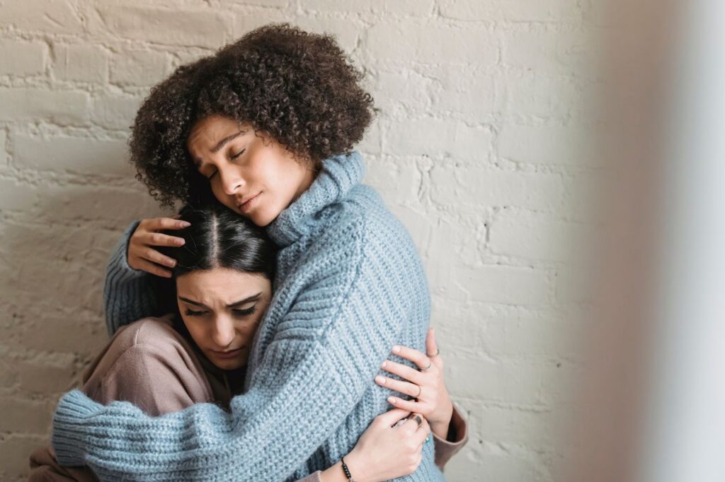 a woman comforting another woman