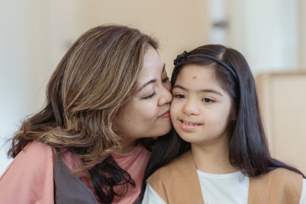 mother kissing her special needs child on the cheek