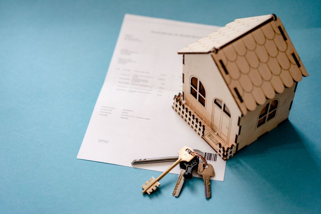 wooden house, keys, and document
