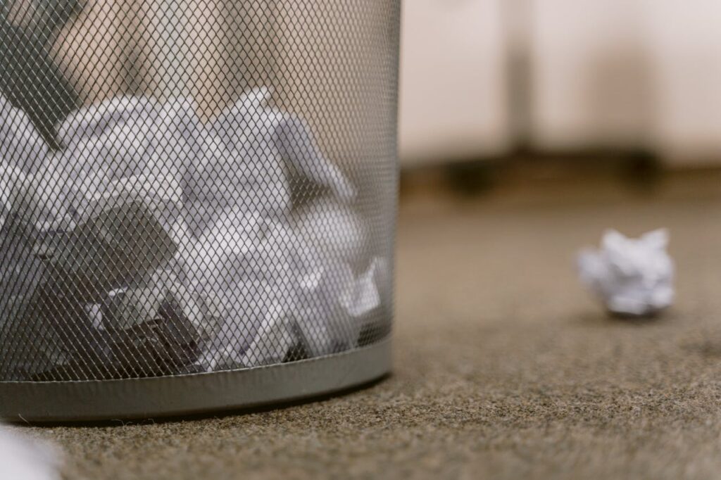 crumpled papers in garbage bin