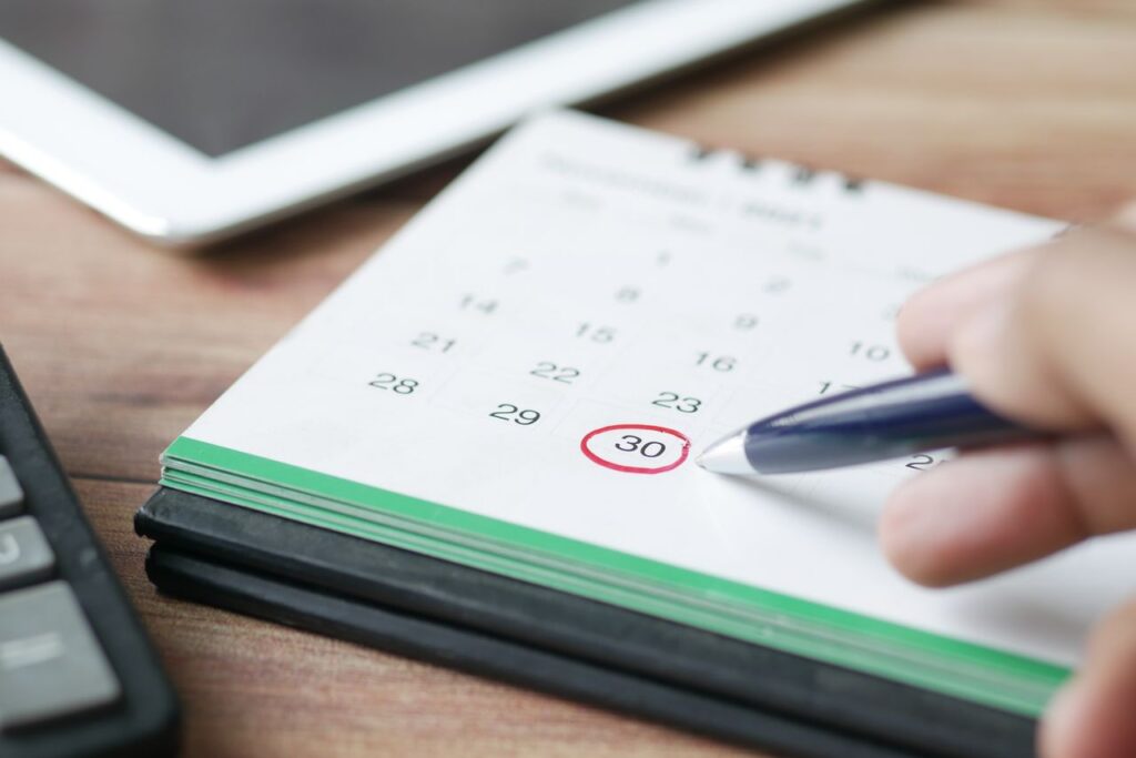 person encircling a date on calendar