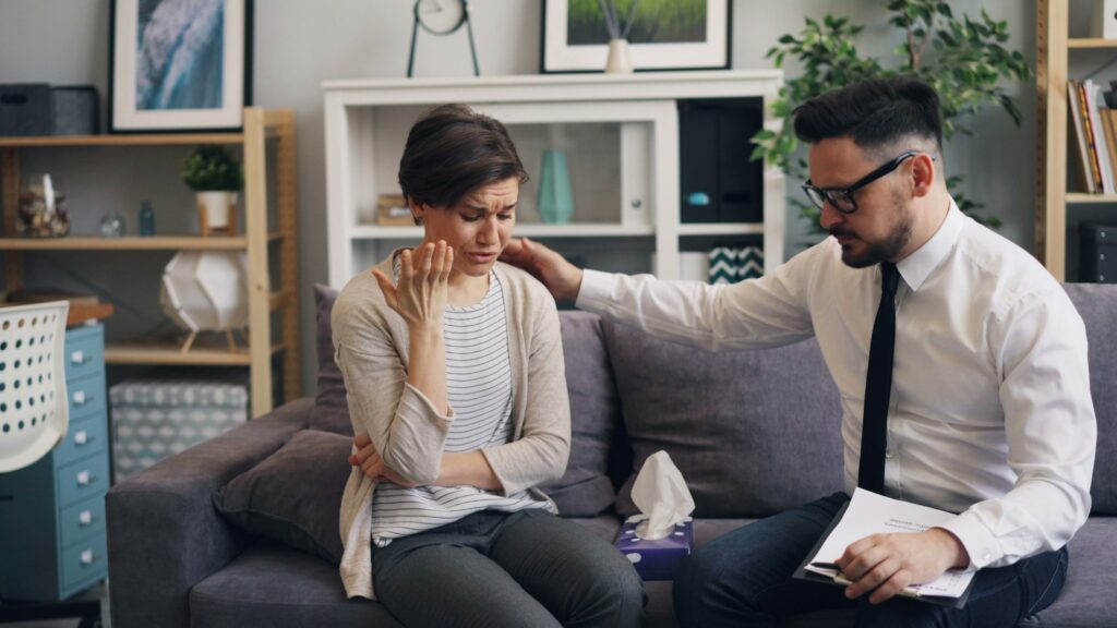 a man and woman crying seated on couch