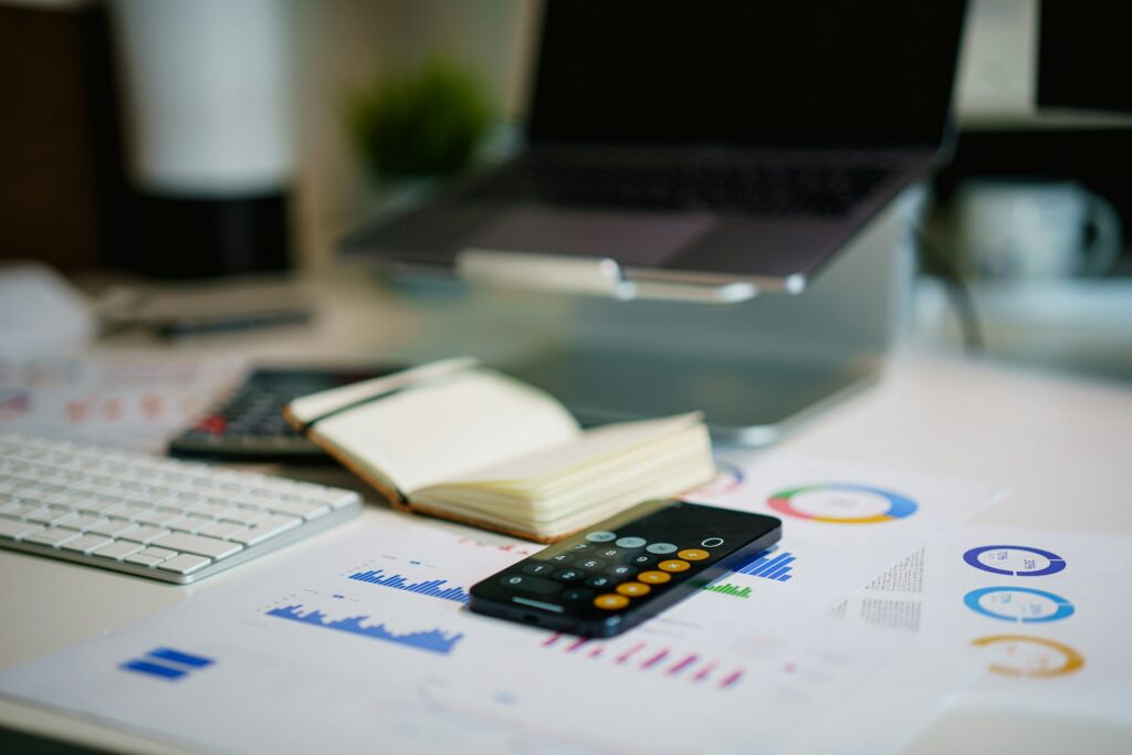 calculator, laptop, notepad, and financial documents