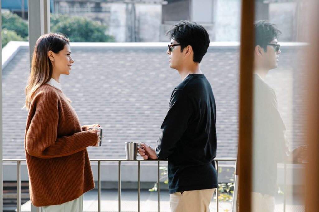 man and woman talking while drinking coffee