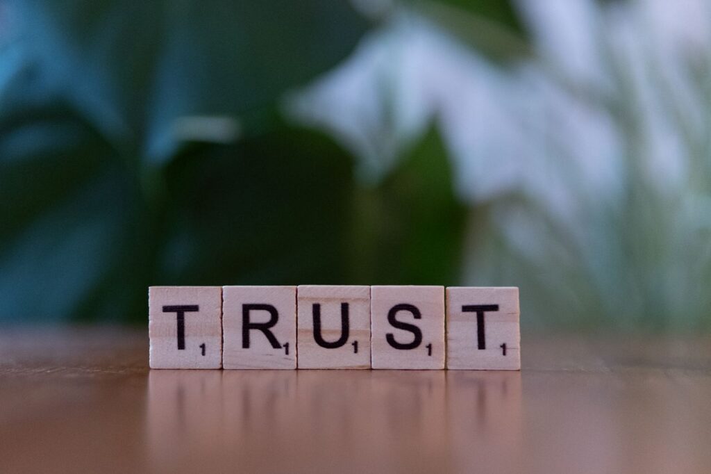 wood letter tiles forming the word "TRUST"