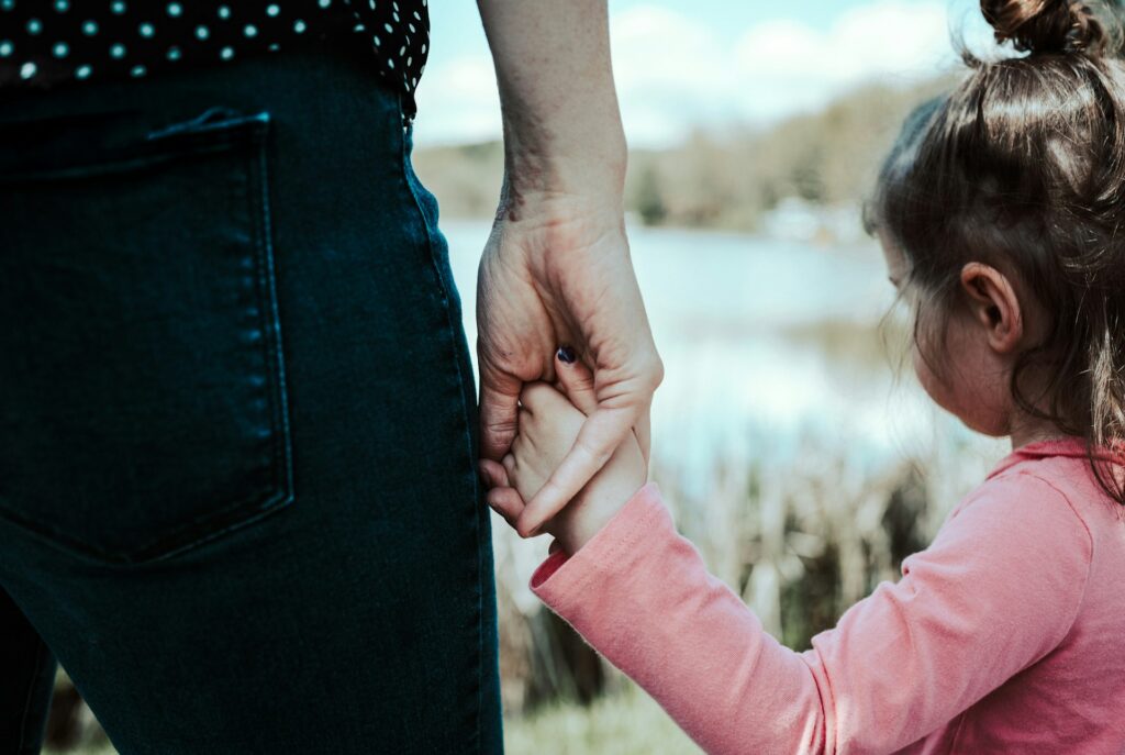 sandra-seitamaa-FWfTtCvgm_8-unsplash an adult holding a child's hand
