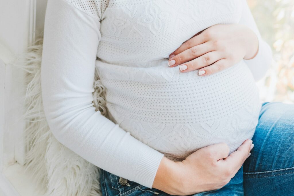 anastasiia-chepinska-B7JVo5y3gL8-unsplash pregnant woman holding her tummy