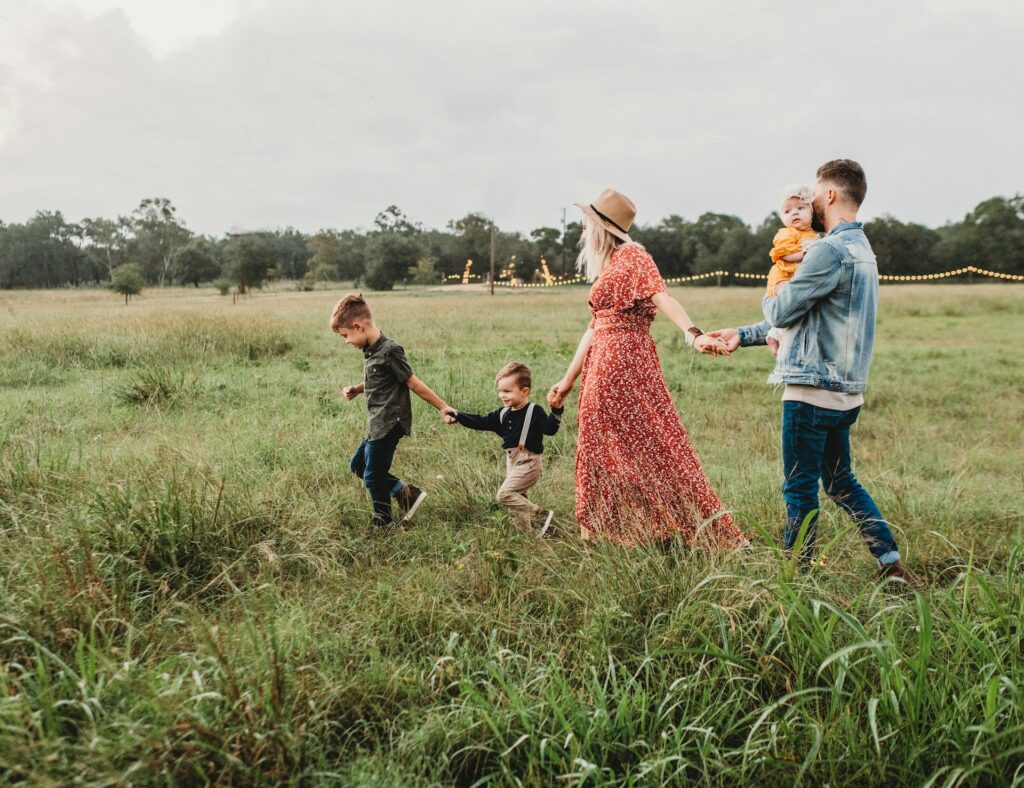 couple and three kids out on a field