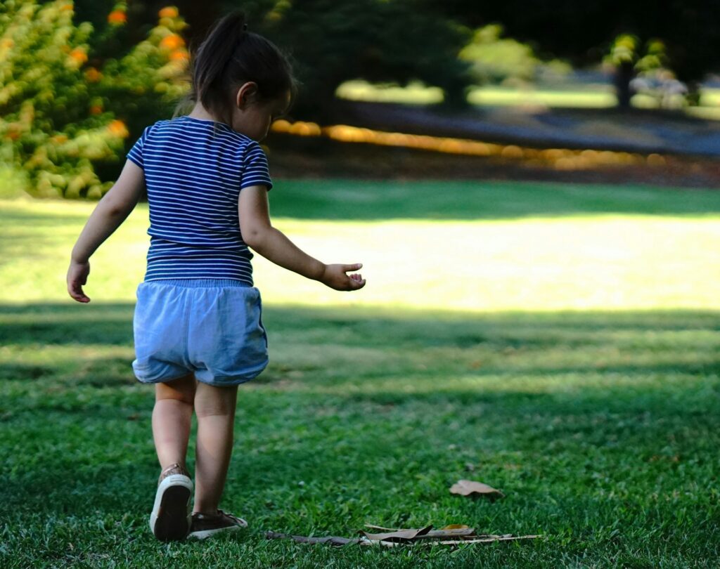 a little girl walking on grass