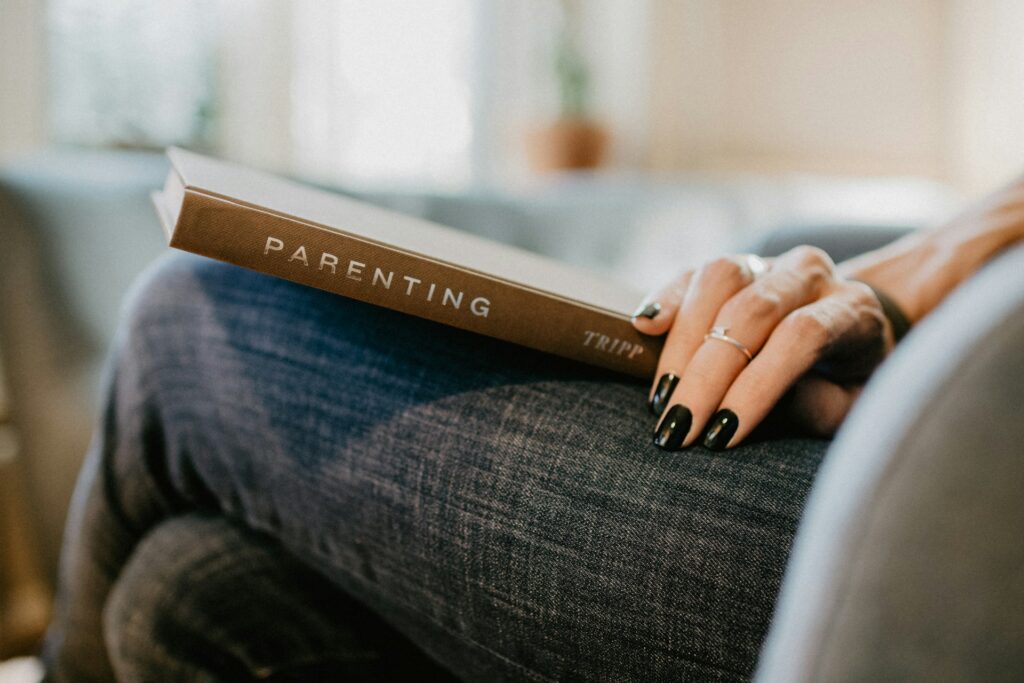 kelly-sikkema-giijfNulwxk-unsplash woman holding a parenting book on her lap