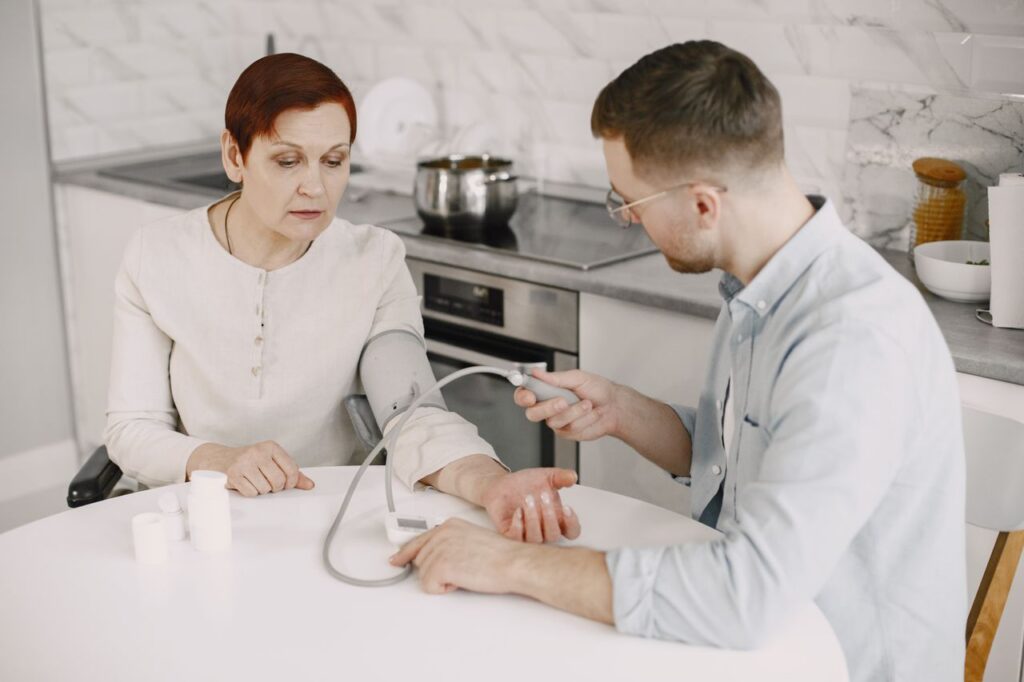 man checking the blood pressure of an elderly woman