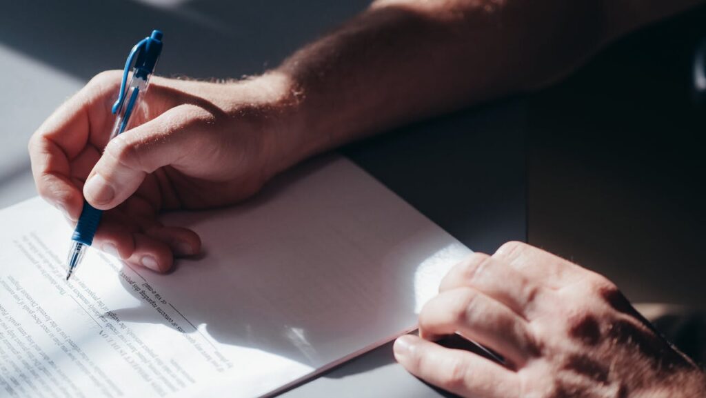 person holding pen while reading document