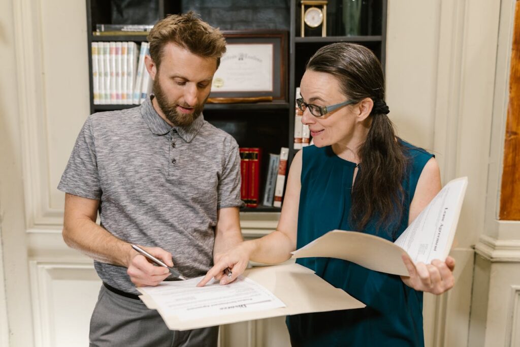 woman pointing at a document for a man to sign