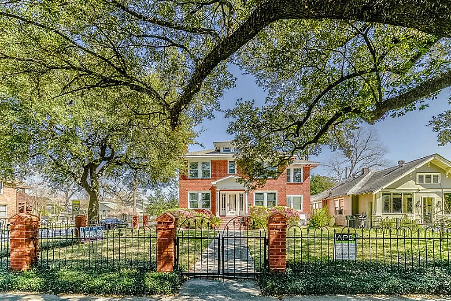 Front exterior view of the Heights office with gated entrance and large oak trees of The Law Office of Bryan Fagan, PLLC