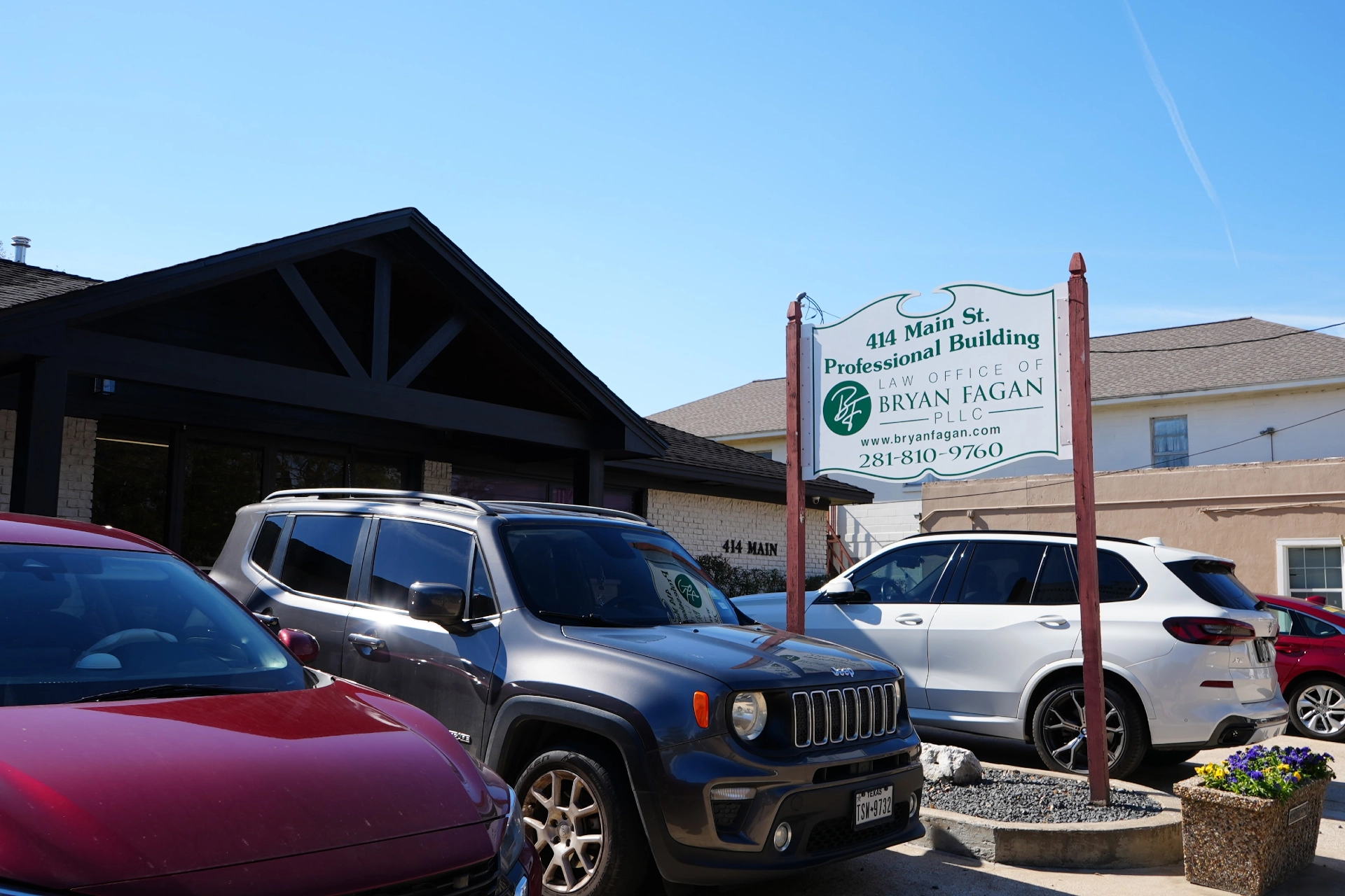 Office building exterior with parking area and signage