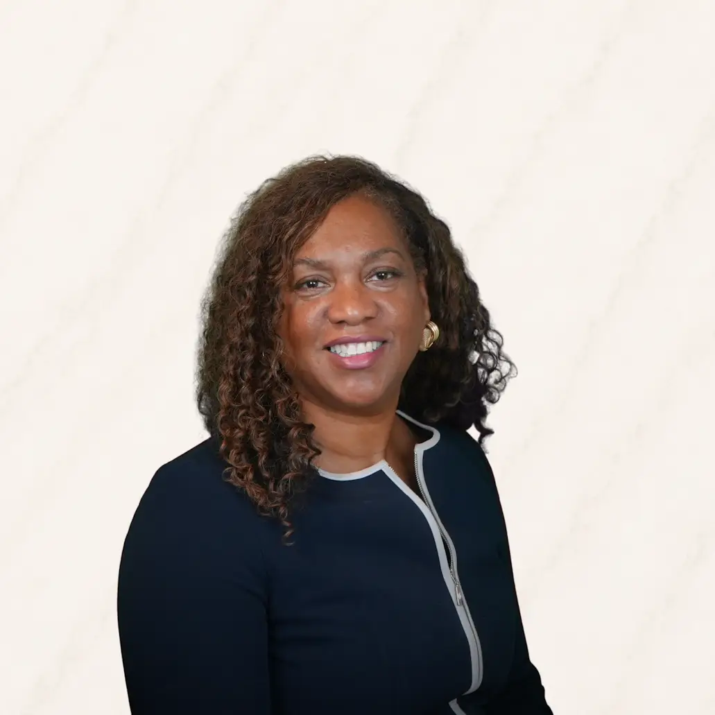 Professional headshot of Cheryl Coleman Driver in a navy blazer with white trim.